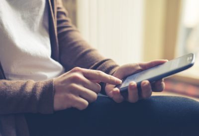 close up of hand woman typing on smart phone