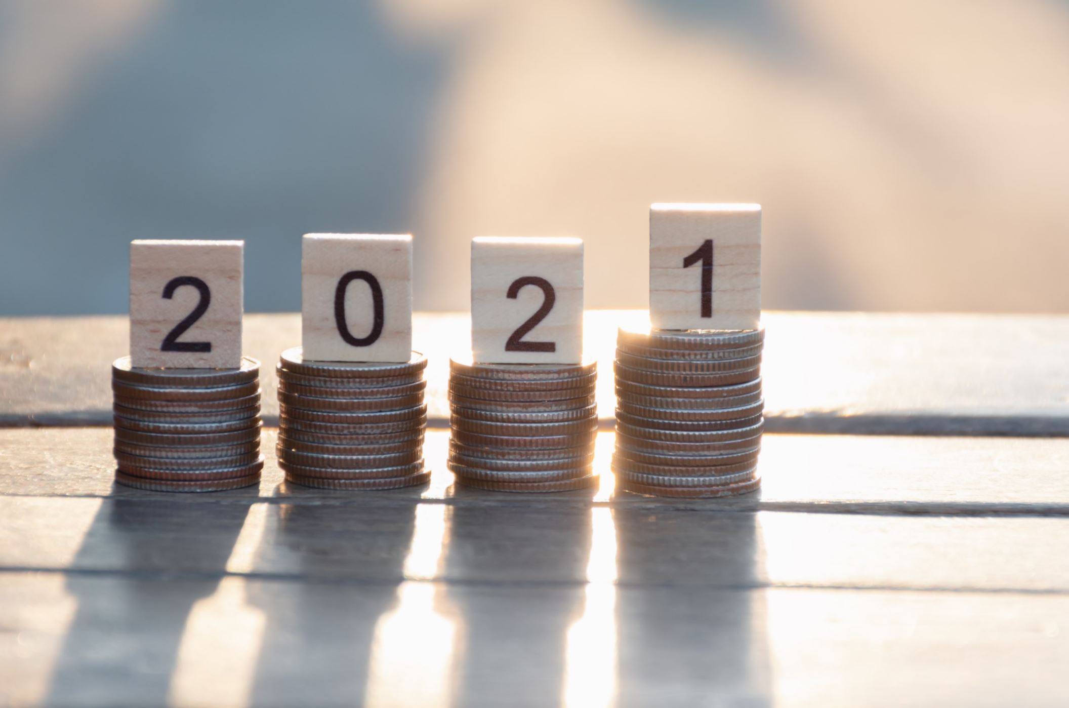 "2021" balancing on a pile of coins