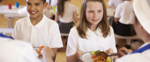 Two school children are handed their lunch