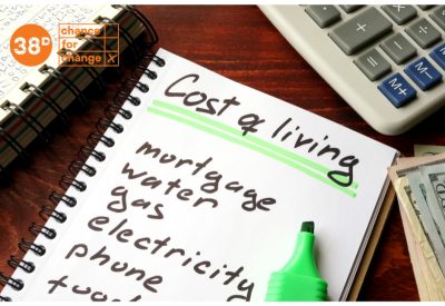 A list written on a pad of paper which says "cost of living" at the top under a list of expenses, including mortgage, electricity and food. An orange logo in the top left corner says "38 degrees, a chance for change"