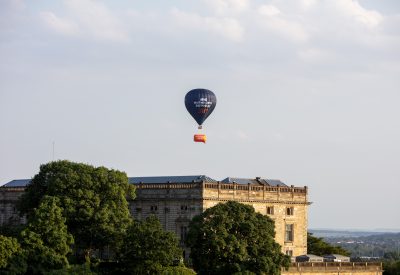 A hot air balloon over a city skyline, with text that reads "NHS waiting lists: Sky high" on it