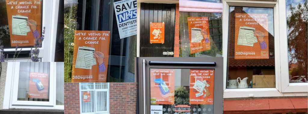 A collage of different windows from different homes, all with orange posters in them reading "a chance for change"