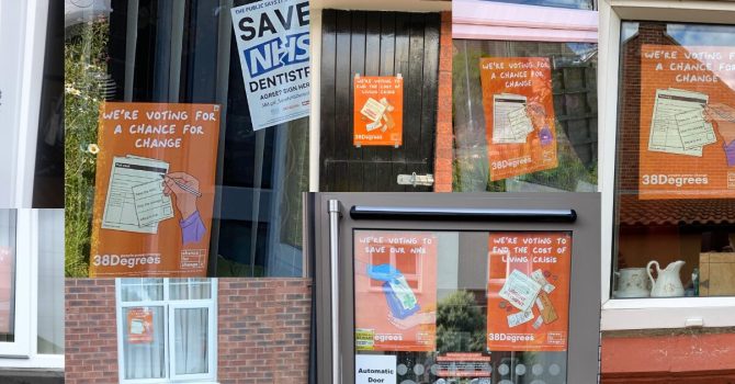 A collage of different windows from different homes, all with orange posters in them reading "a chance for change"